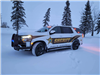 A squad car with it's lights on during winter