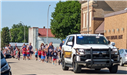 Sheriff Tadman and a parade follow behind a squad car
