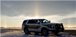 A sundog rises behind a squad car