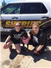 Two Girls with Dog in Front of Police Sheriff Car
