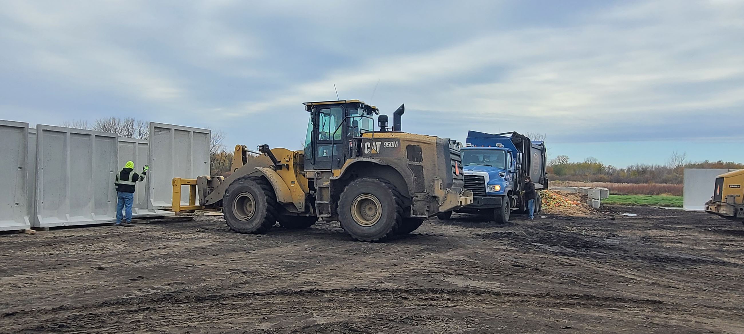 Landfill staff unloading a concrete L-panel 